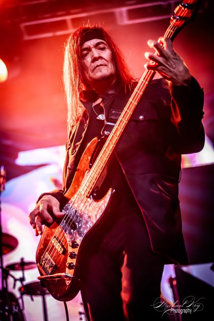 Bassist under red and white light.