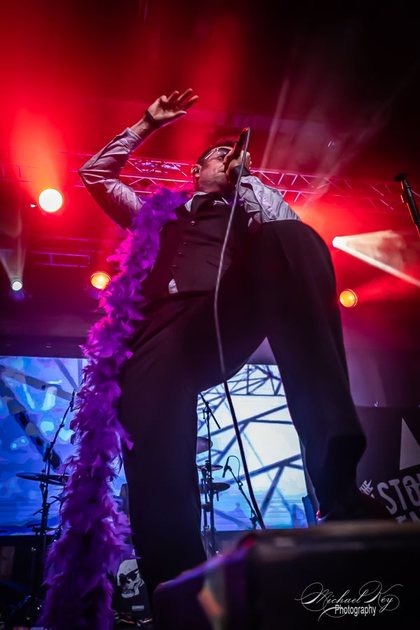The singer from below, arm raised.